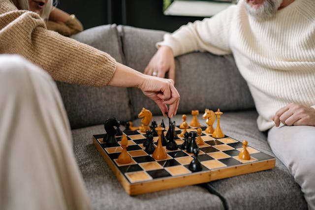 elderly people playing chess in care home on the sofa