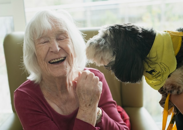resident smiling with therapy dog
