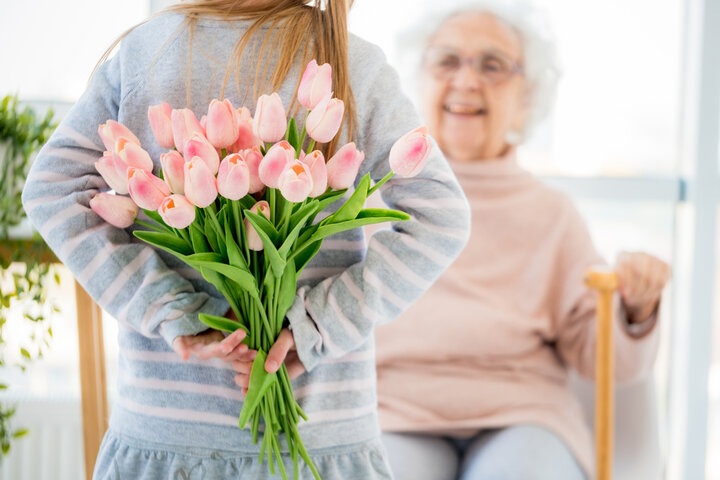 granddaughter holding flowers for her grandma