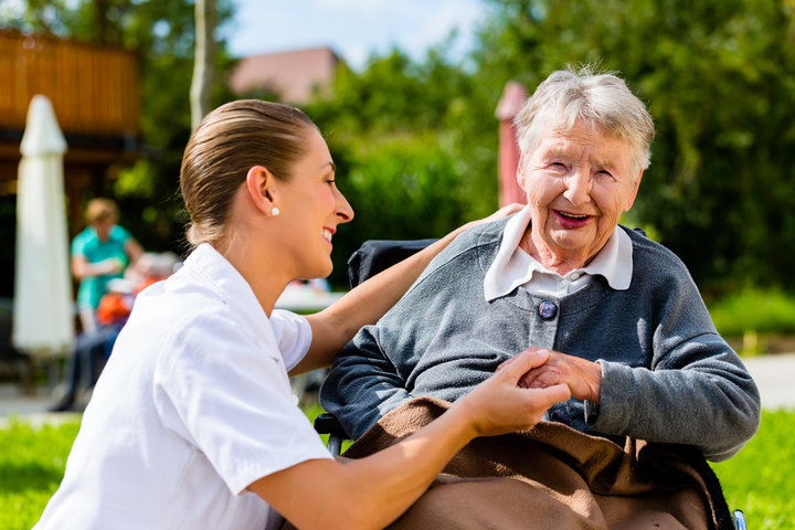 woman in wheel chair with nurse in care home